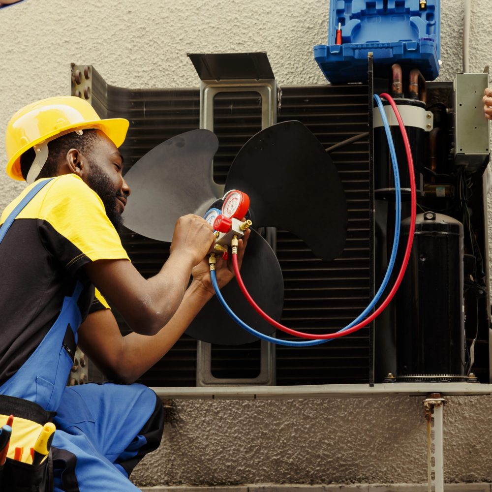 Proficient worker expertly refilling refrigerant in HVAC system while using barometer gauges to correctly measure the pressure in condenser, ensuring right cooling performance